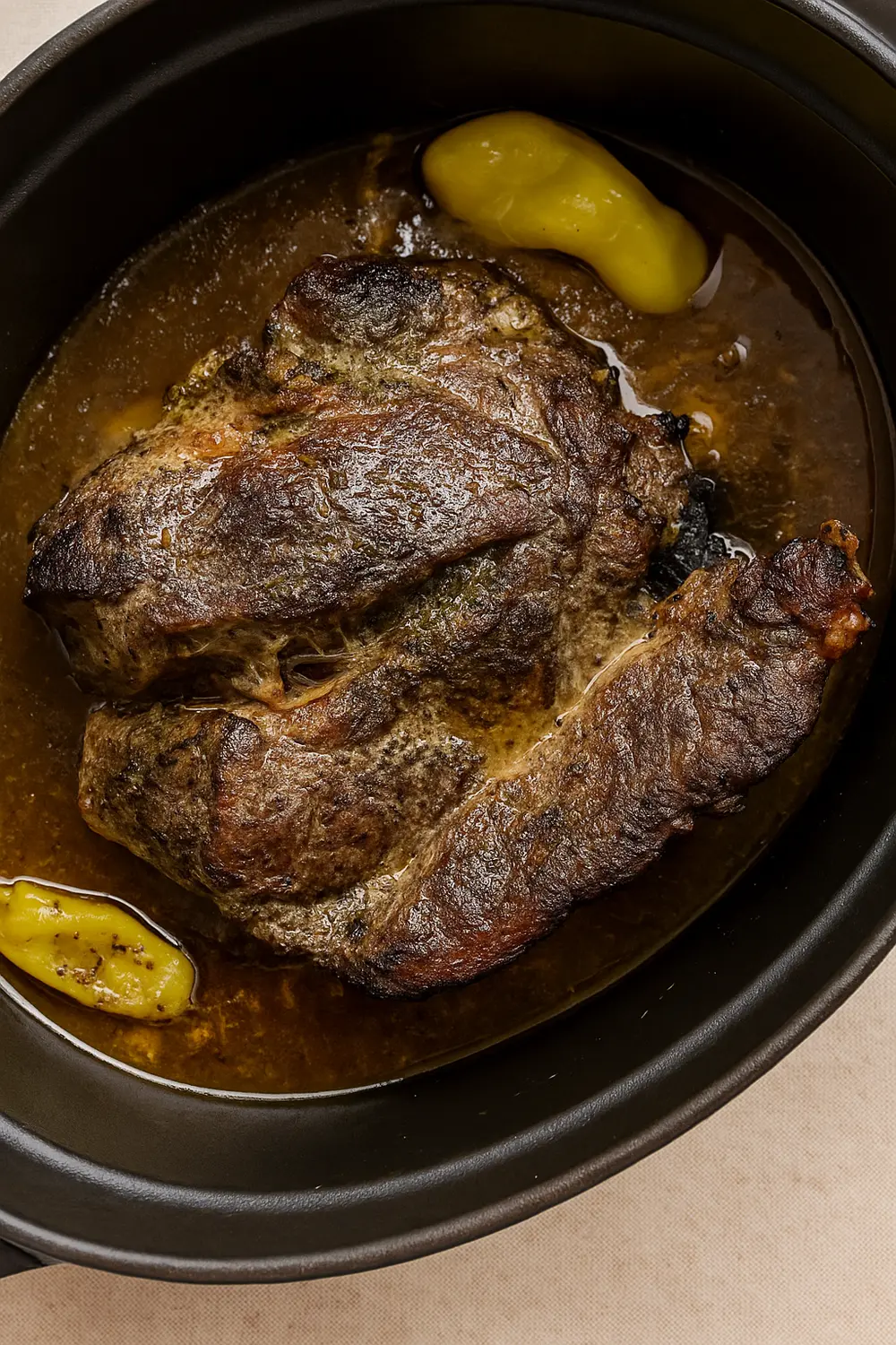 Slow cooker pot roast recipe featuring tender beef, pepperoncini, and rich buttery gravy, perfect for Thanksgiving or Christmas dinner.